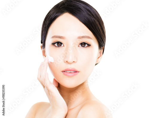 Beautiful women applying moisturizer cosmetic cream on face
