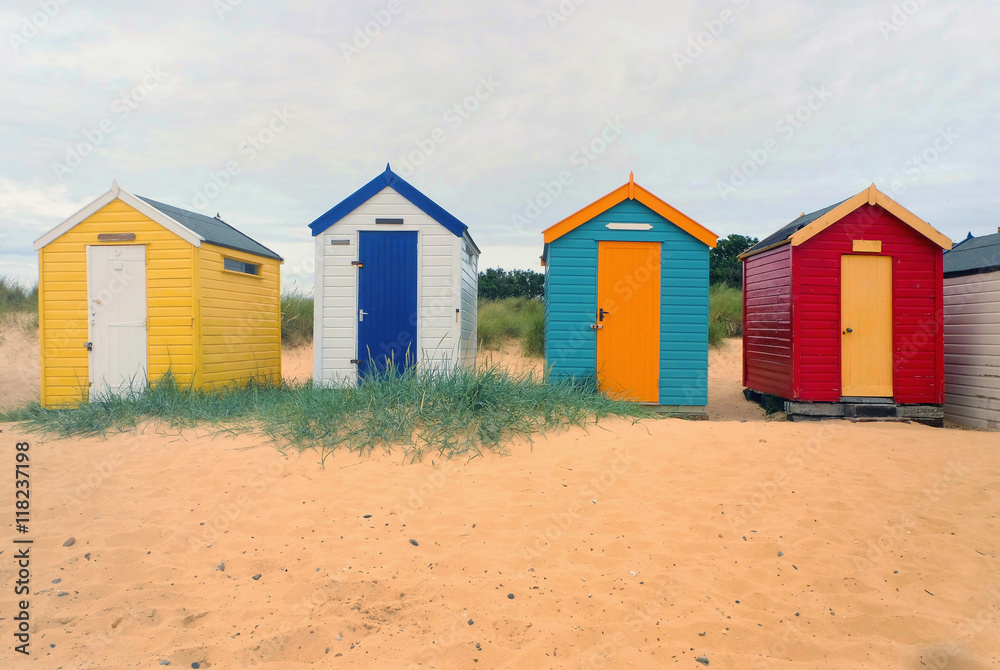 Front view of a row four multi-coloured beach huts, Southwold, Suffolk, UK Front view of a row four multi-coloured beach huts, Southwold, Suffolk, UK