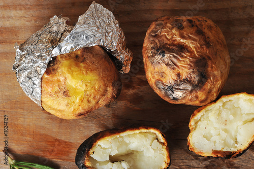 potatoes baked in foil on a wooden background