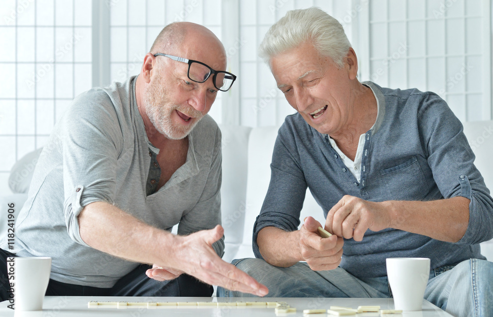 two senior men  playing domino