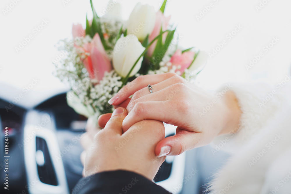 Hands of bride and groom on wedding bouquet. Marriage concept Hands of bride and groom on wedding bouquet. Marriage concept