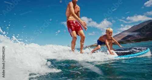 Father and son having fun surfing together, summer lifestyle family time