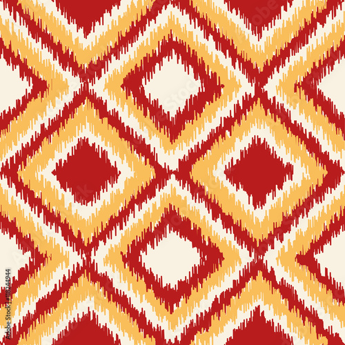 Ikat fabric pattern, abstract geometric pattern with diamond shapes . Seamless vector background.  Vector illustration. Oriental rug pattern, in yellow, orange and red.