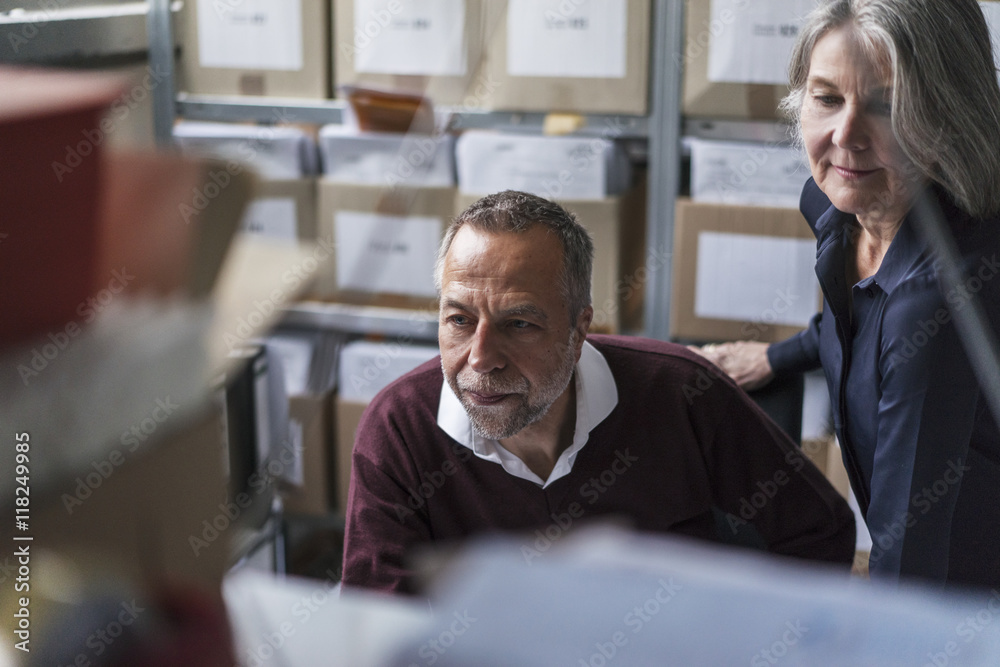 Senior woman and man in a factory scrutinizing Senior woman and man in a factory scrutinizing