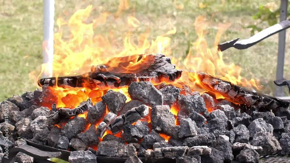 A blacksmith models a bar of iron with hammer after took it from fire forge. A blacksmith models a bar of iron with hammer after took it from fire forge.