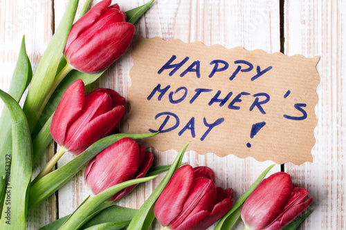 Happy Mother's Day card and a bouquet of beautiful tulips on wooden background