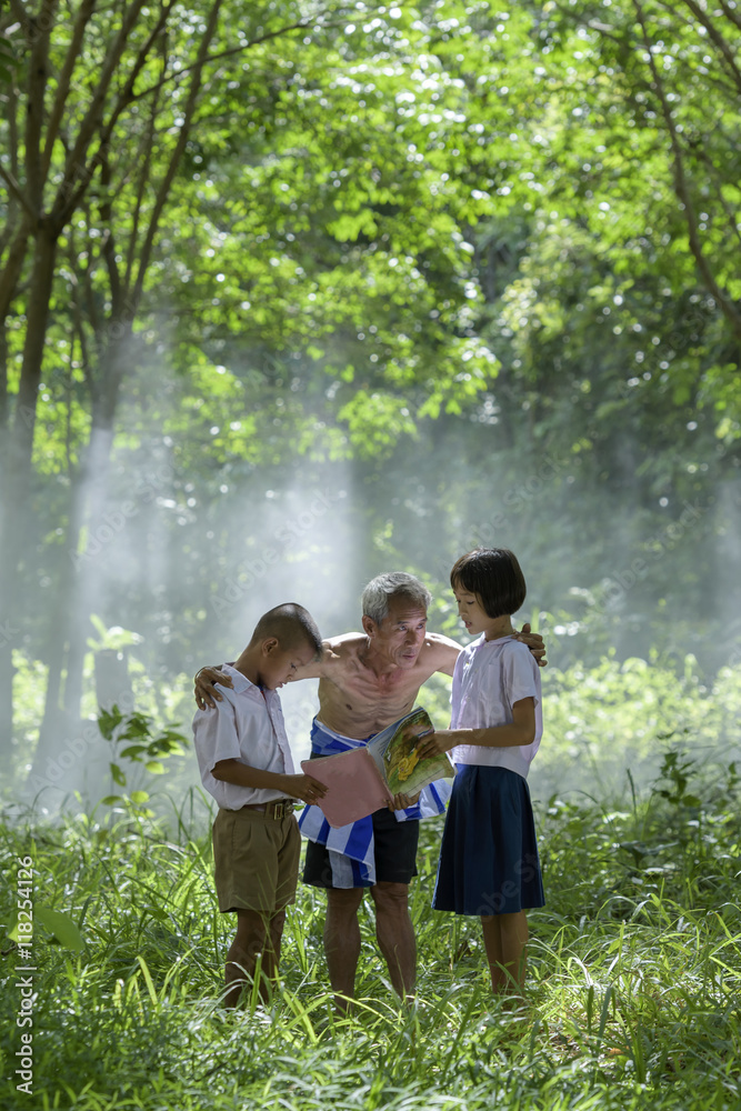 Fototapeta premium Happy children is reading book in rubber plantation