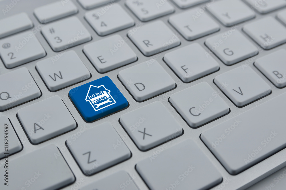 Hammer and wrench with house icon on modern computer keyboard bu Hammer and wrench with house icon on modern computer keyboard bu