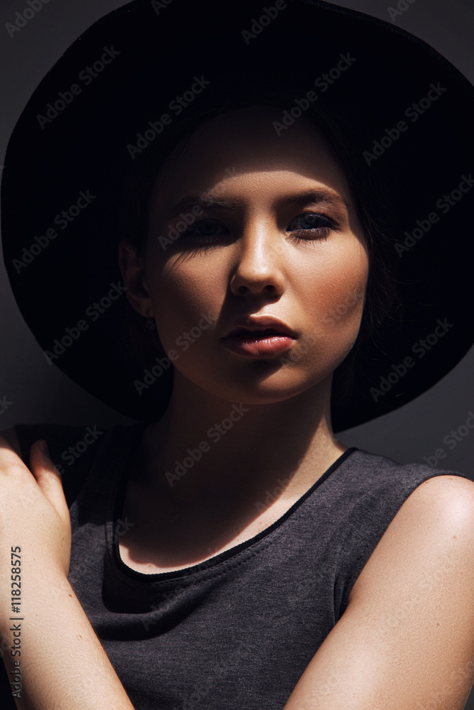 High fashion look.glamor closeup portrait of beautiful stylish Caucasian young woman model with perfect clean skin in big black hat High fashion look.glamor closeup portrait of beautiful stylish Caucasian young woman model with perfect clean skin in big black hat