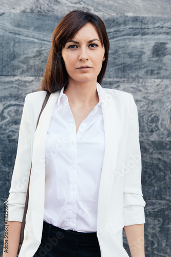 Successful businesswoman in white shirt looking away photo