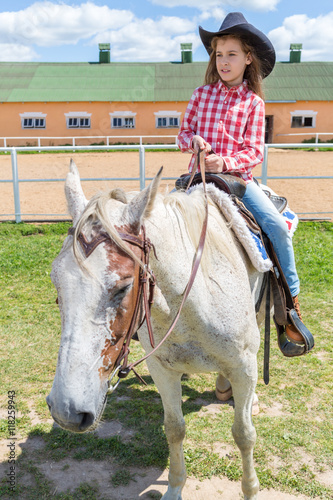 cowboy girl on horseback looks into the distance