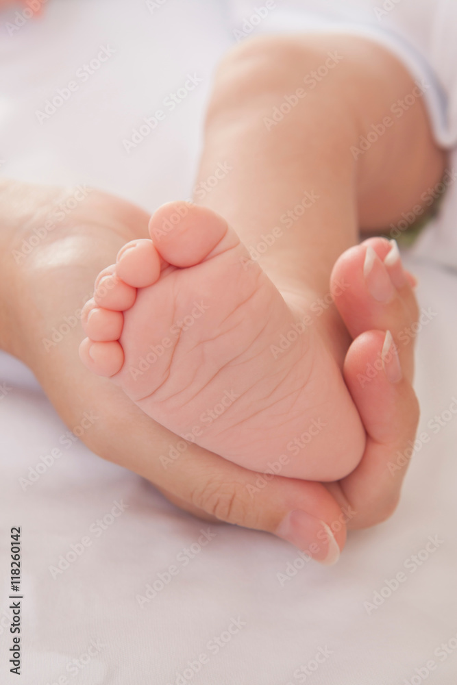 Mothers hand holding baby boys foot Mothers hand holding baby boys foot
