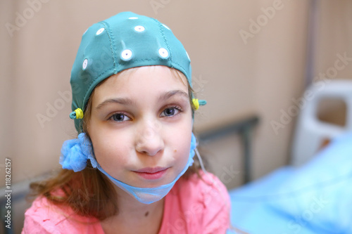Portrait of girl in a special cap for electroencephalography in the hospital photo