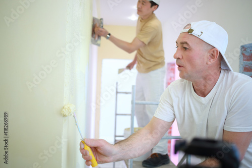 Two builders making finish in the apartment photo