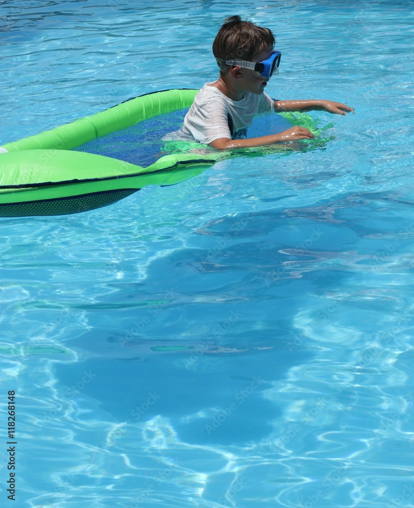 A young boy playing in a swimming pool while on vacation, 2016