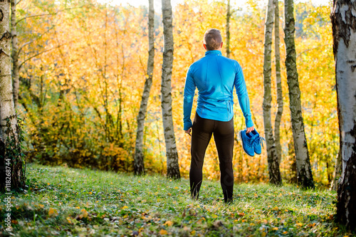 Young handsome hipster runner outside in sunny autumn nature © Halfpoint
