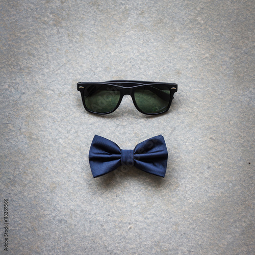Men's casual, bowtie with sunglasses on gray flat lay background