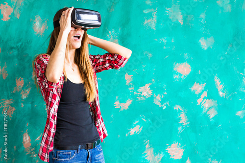 Happy woman getting experience using VR-headset glasses of virtual reality much gesticulating hands © satura_