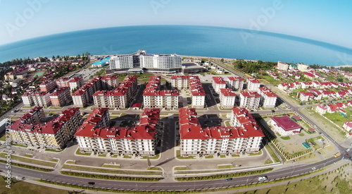 Street traffic near town-hotel Barhatnye Sezony and hotel Radisson Blu on sea shore at summer sunny day. Aerial view. Photo with noise from action camera. photo