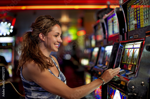 Caucasian woman playing slot machine in casino photo