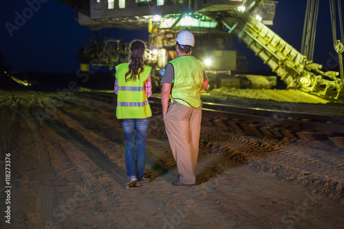 two workers go across the sand career stacker
