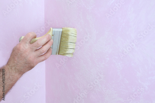 Male hand with a brush during the painting walls photo