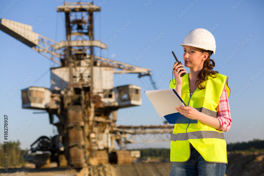 female worker talking on a radio on a background of career Stacker female worker talking on a radio on a background of career Stacker