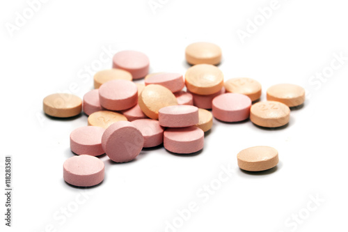 pink pills on a small heap isolated with shadows on a white background