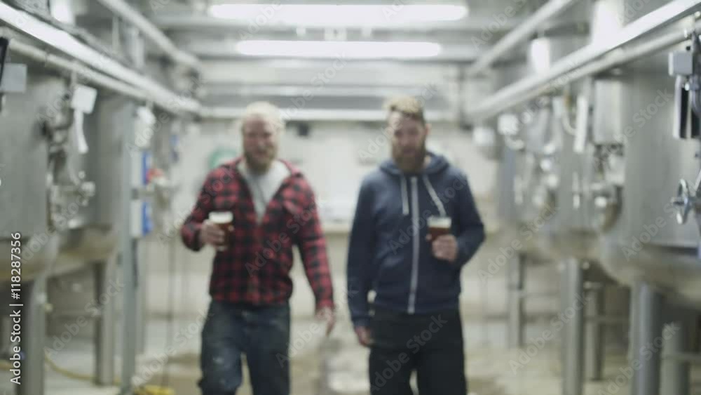Portrait of smiling brewery workers enjoying a glass of the finished product. Portrait of smiling brewery workers enjoying a glass of the finished product.