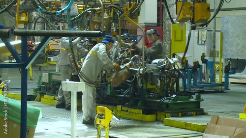 Car Production. Three Asian Workers do Perform Welding Work