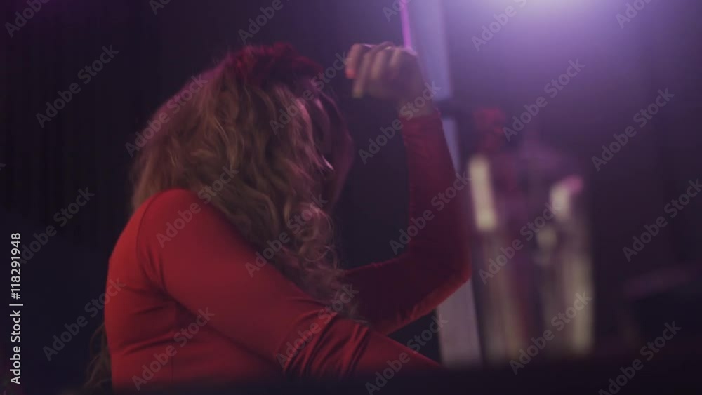 Dj girl in red dress spinning at turntable in nightclub. Performance. Dancing. Mixing Dj girl in red dress spinning at turntable in nightclub. Performance. Dancing. Mixing