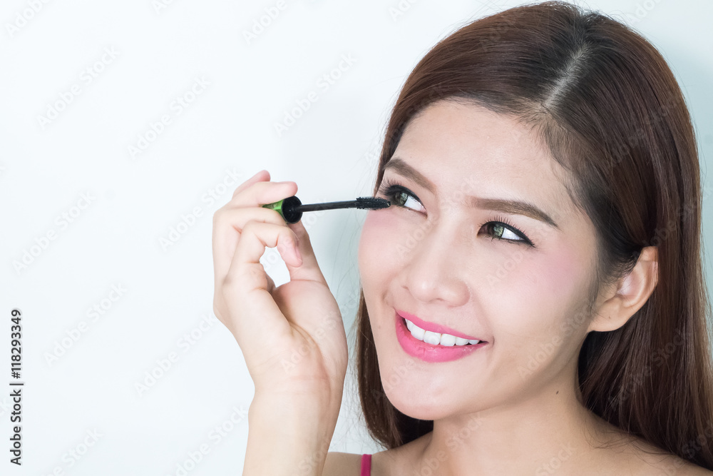Makeup woman putting mascara eye make up on eyes. Asian fresh fa Makeup woman putting mascara eye make up on eyes. Asian fresh fa