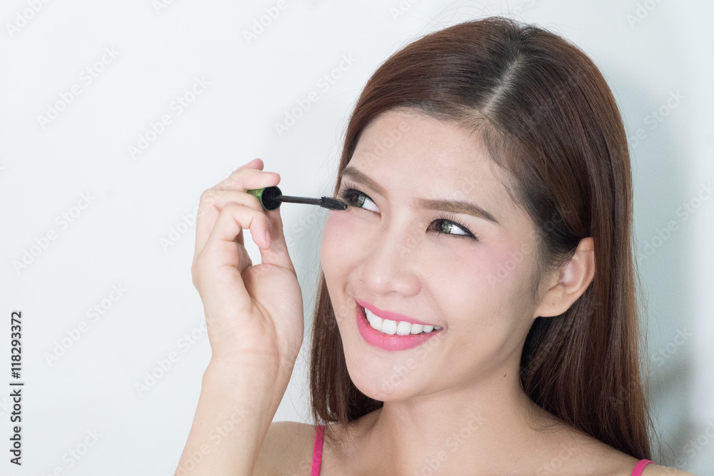 Makeup woman putting mascara eye make up on eyes. Asian fresh fa Makeup woman putting mascara eye make up on eyes. Asian fresh fa