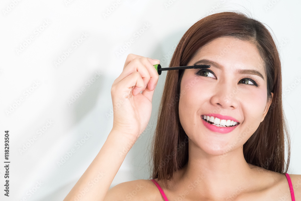 Makeup woman putting mascara eye make up on eyes. Asian fresh fa Makeup woman putting mascara eye make up on eyes. Asian fresh fa