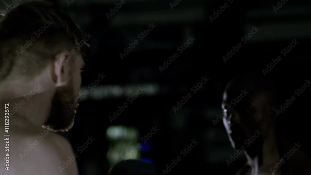  MMA fighter training with partner in dark environment