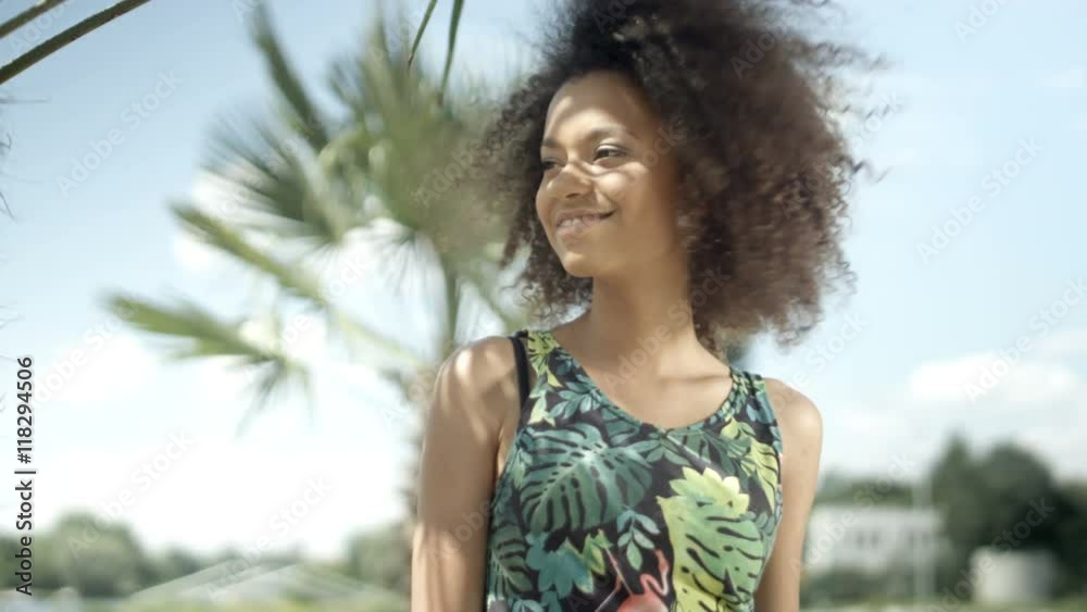 Portrait of beautiful teenage Afro American girl on tropical beach smiling to a camera. Portrait of beautiful teenage Afro American girl on tropical beach smiling to a camera.