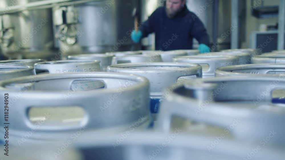 Worker in a brewery preparing barrels of beer for distribution Worker in a brewery preparing barrels of beer for distribution
