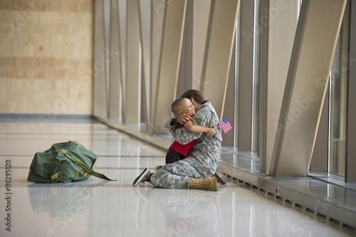 Female soldier hugging son in airport