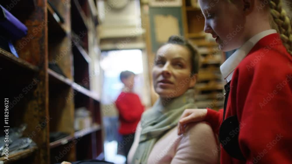 Mother shopping with her children in school uniform supply store vídeo