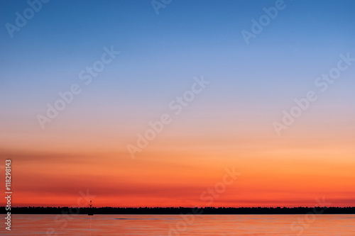 Sunset at sea with shades of orange, magenta and blue in the sky