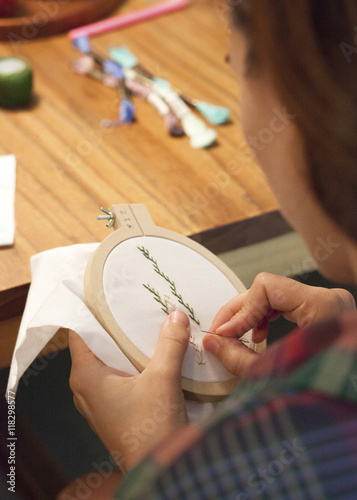 Close up of woman hand-stitching embroidery photo