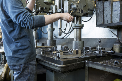 Caucasian man using drilling machine in workshop