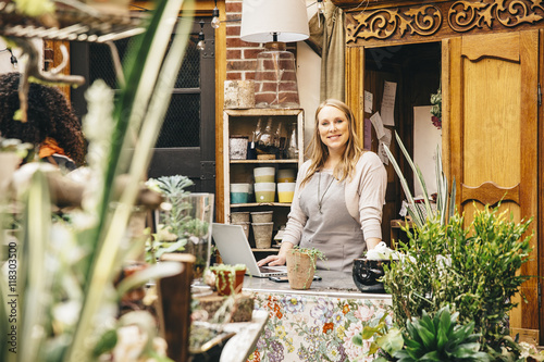 Caucasian employee using laptop in plant nursery