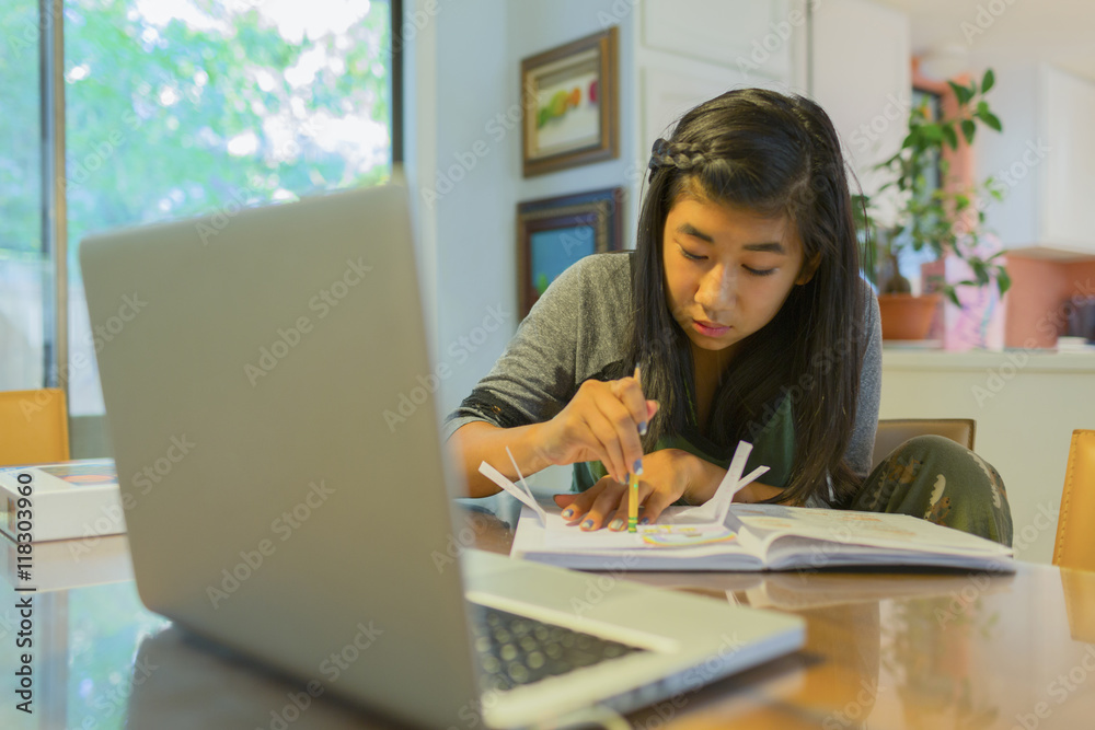 Chinese girl doing homework at table Chinese girl doing homework at table
