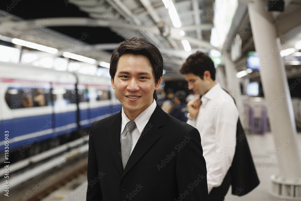 Businessmen waiting on platform for subway train Businessmen waiting on platform for subway train