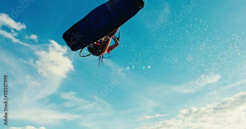 Beautiful young woman kiteboarding at sunset in slow motion, active lifestyle extreme sport