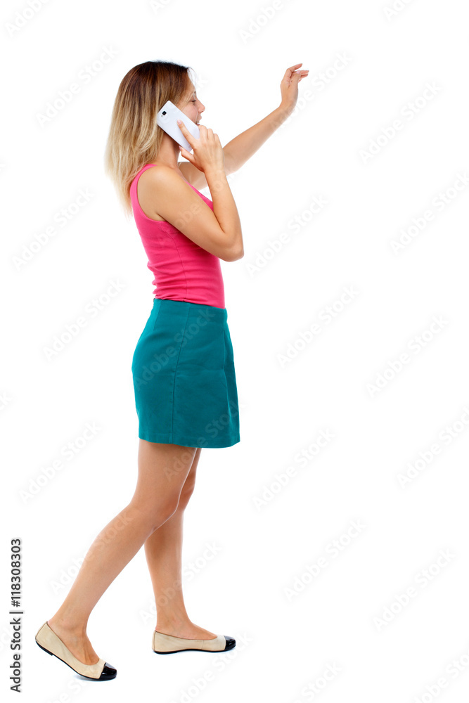 side view of a woman walking with a mobile phone. back view ofgirl in motion. backside view of person. Rear view people collection. Isolated over white background. Blonde in a red sweater and green side view of a woman walking with a mobile phone. back view ofgirl in motion. backside view of person. Rear view people collection. Isolated over white background. Blonde in a red sweater and green