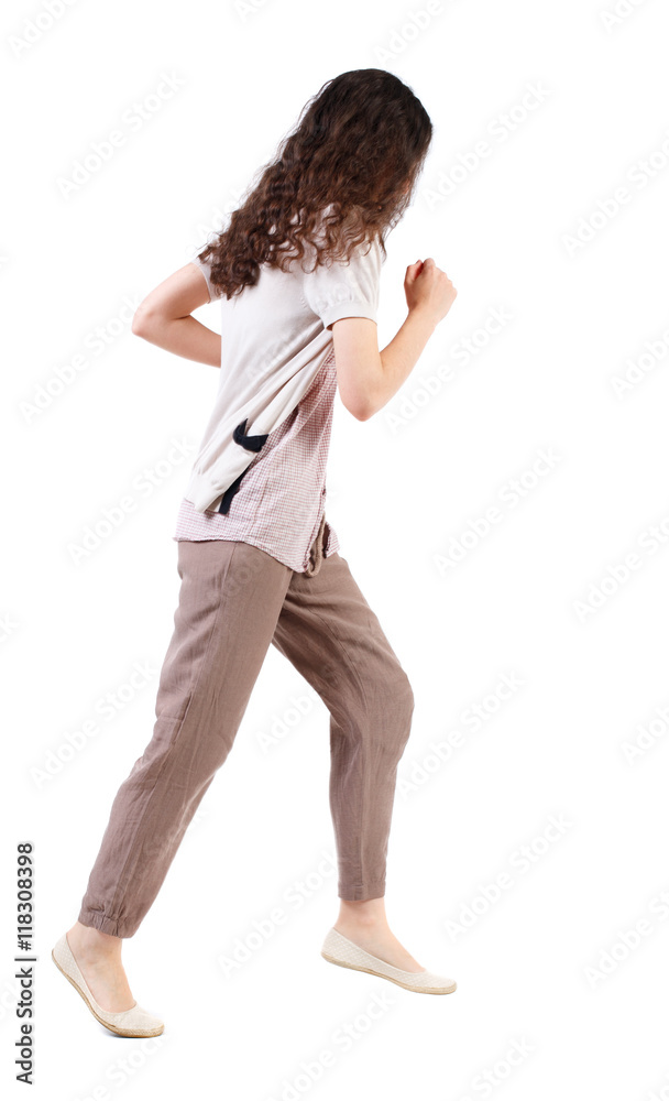 side view of running  woman. beautiful girl in motion. backside view of person.  Rear view people collection. Isolated over white background. Long-haired curly girl runs past the camera.