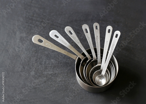Fotografía Silver Measuring Cups Stacked on Black Background