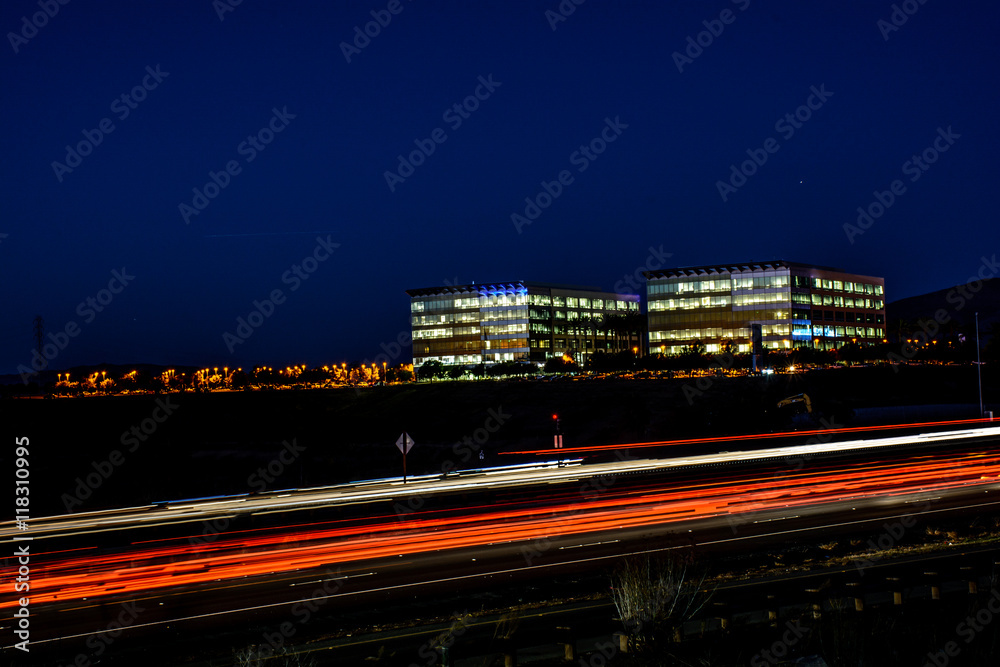 Fototapeta premium Busy Silicon Valley Night Freeway and Office Cityscape